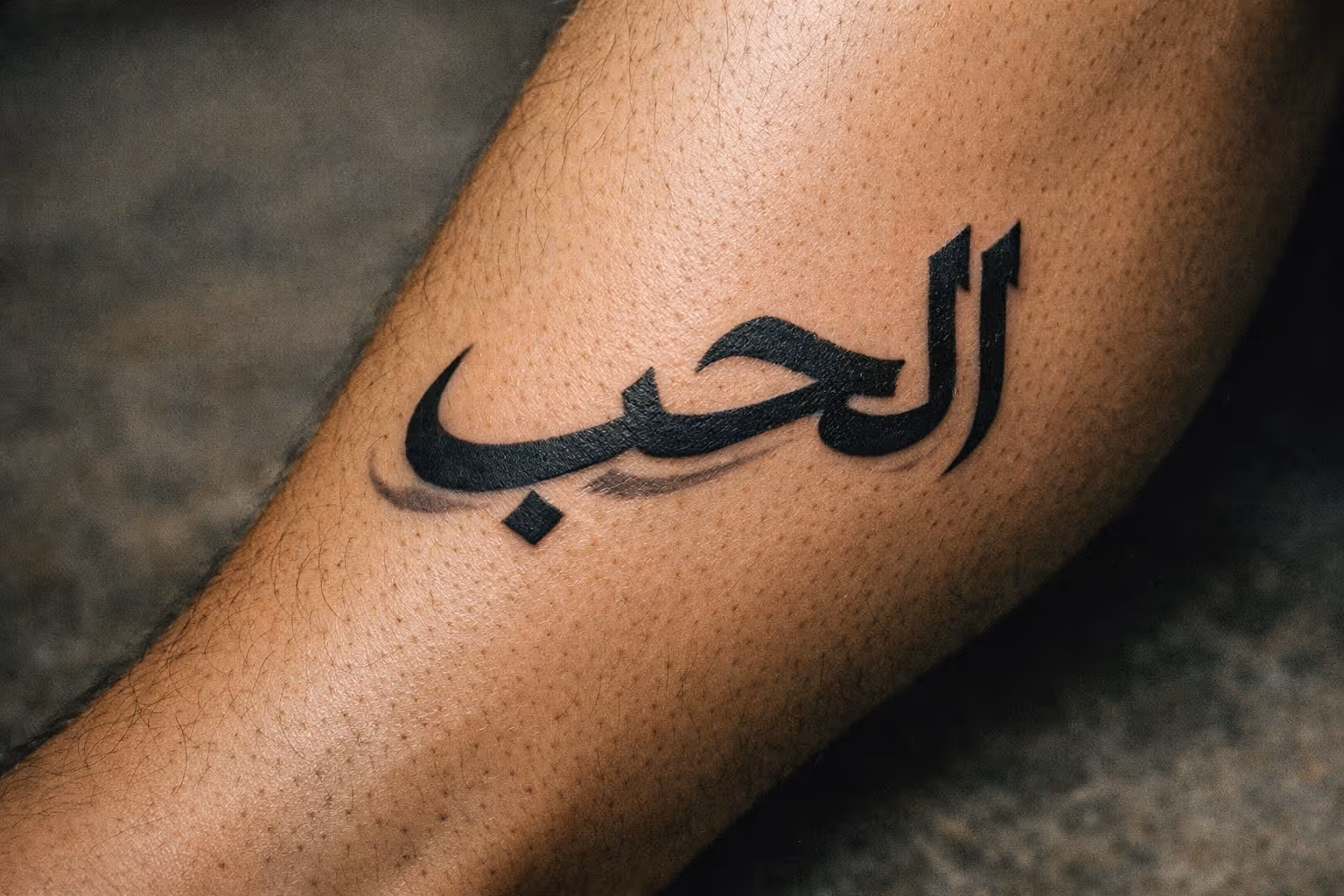 A leg with a clear Arabic script tattoo displayed prominently on the skin.