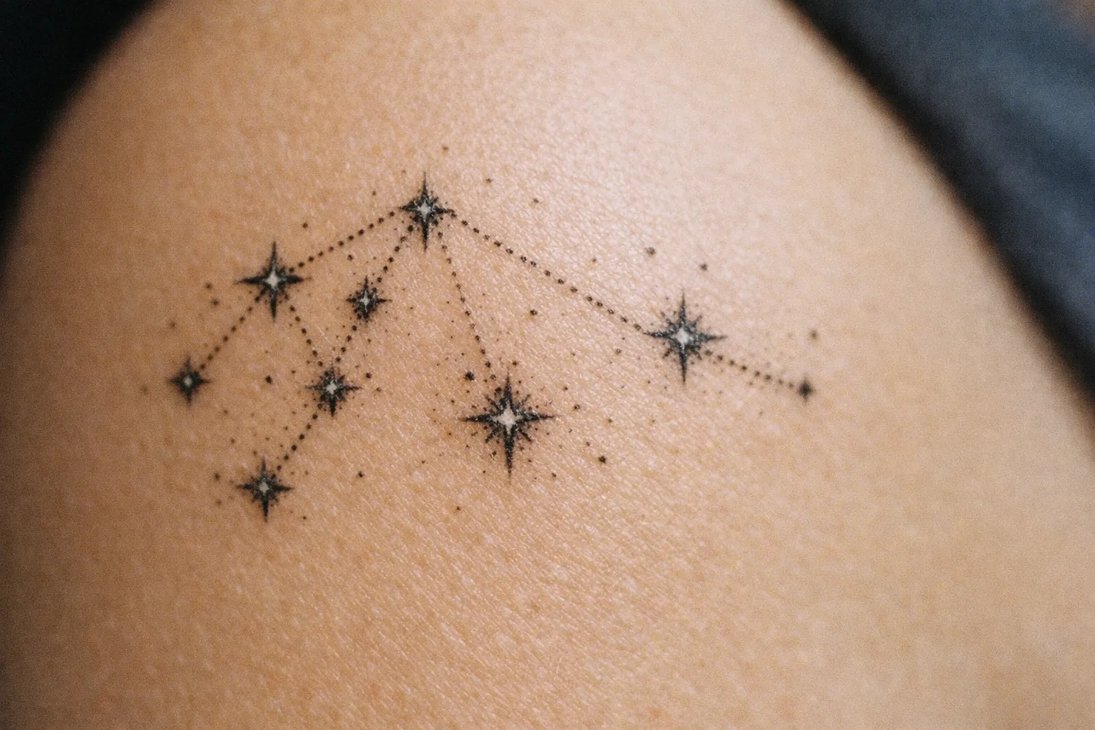 A constellation tattoo is inked on a person's shoulder.