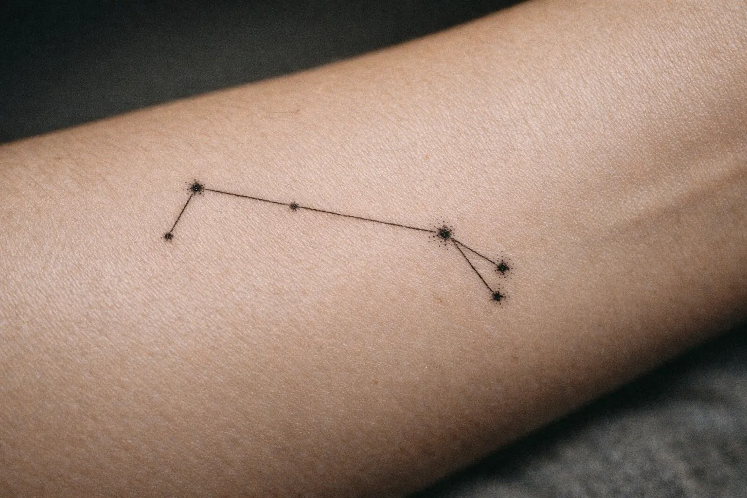 Fine-line Aries constellation tattoo on inner forearm with delicate linework