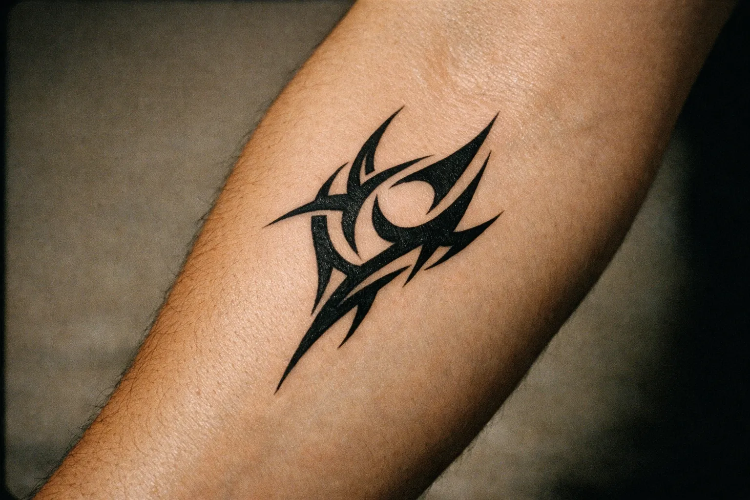Forearm close-up with bold black linework tattoo