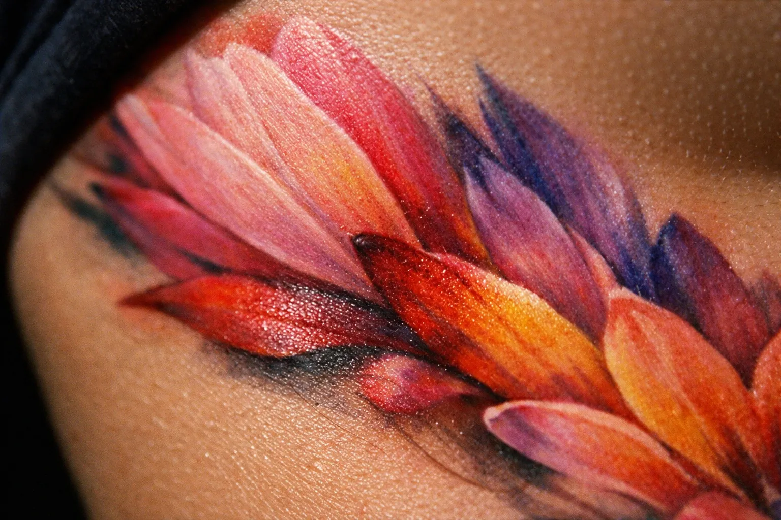 A vibrant floral tattoo covers the skin near a person's breast.