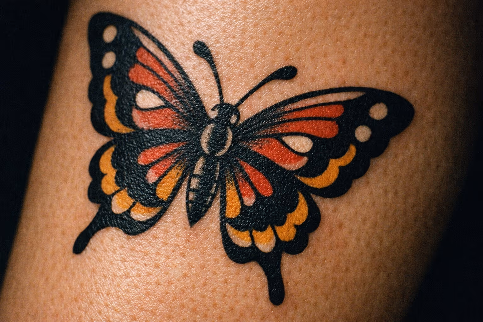 A colorful butterfly tattoo on a person's skin.