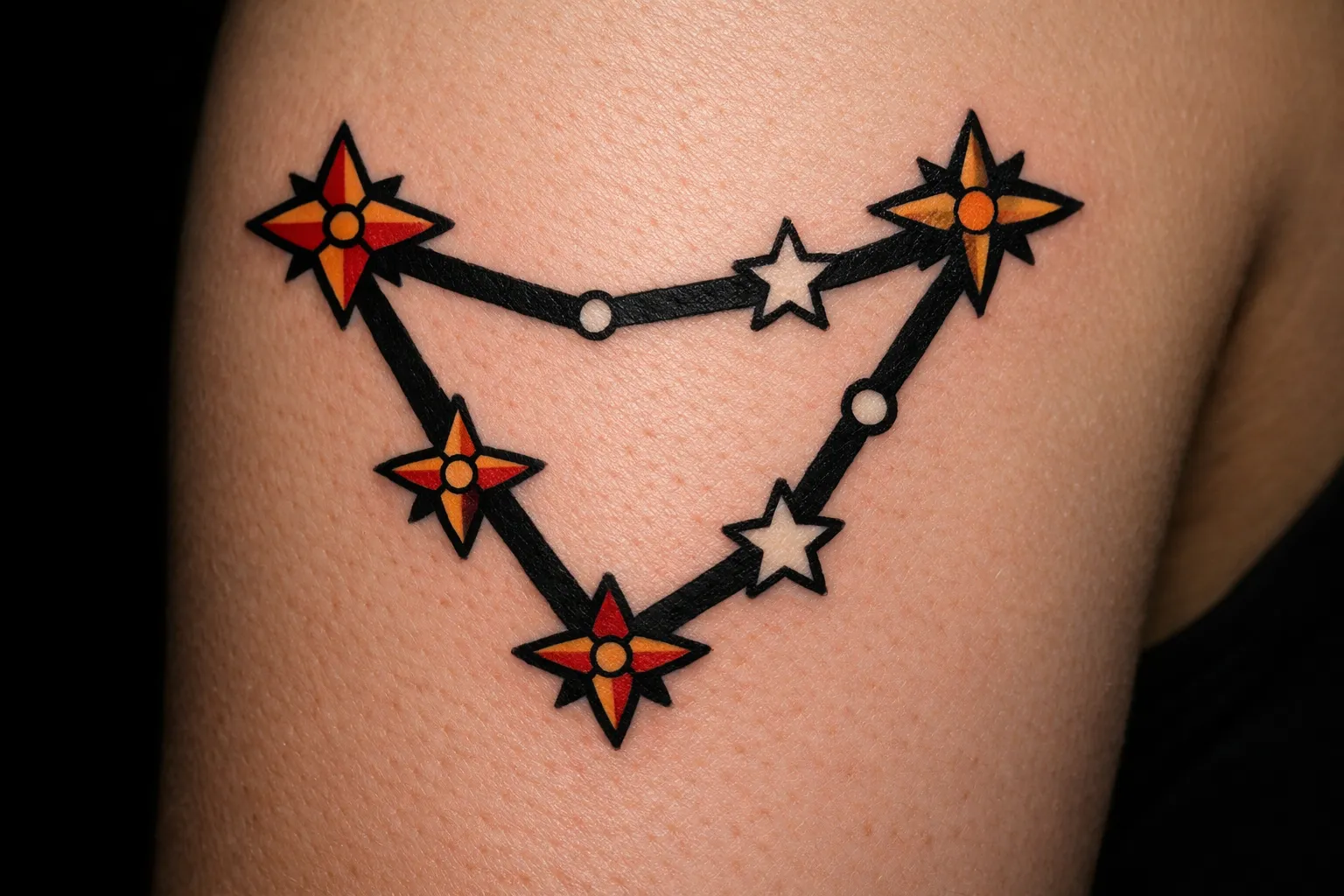 A colorful Capricorn constellation tattoo on a person's upper arm.