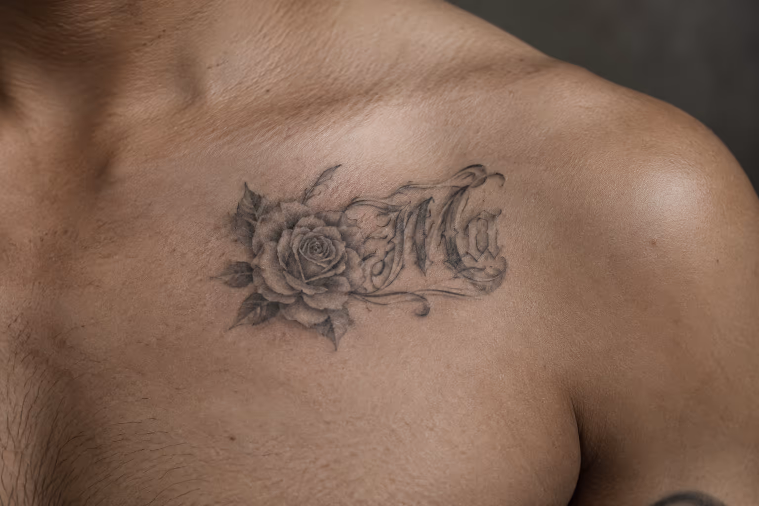 A black-and-gray rose and ornate lettering tattoo spans a person's upper chest.