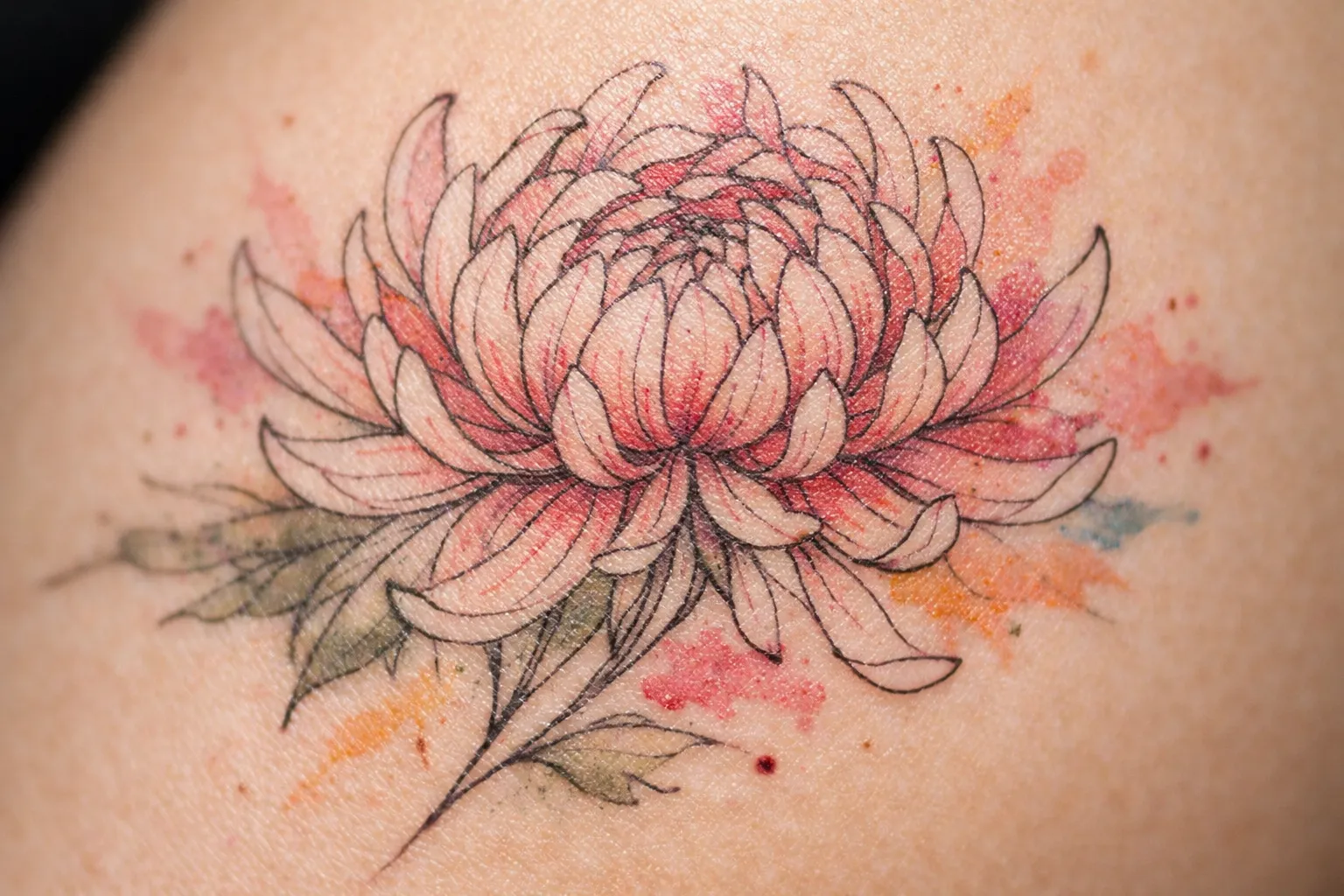 A chrysanthemum flower tattoo on human skin with watercolor-style shading.