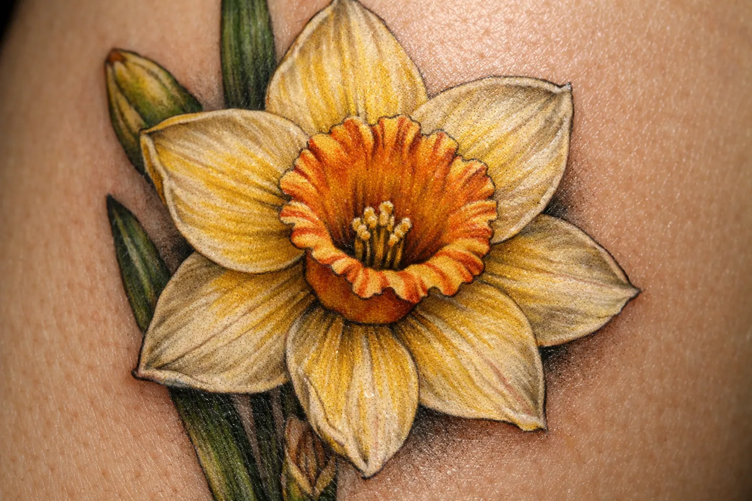 A daffodil flower tattoo on light skin.