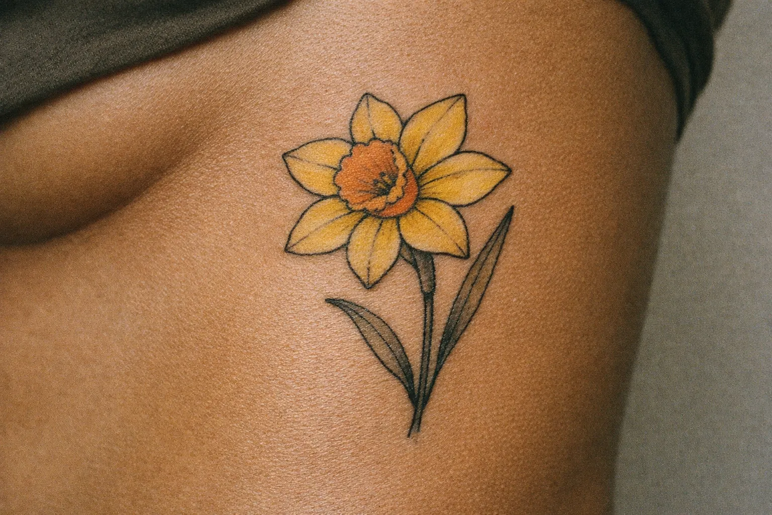 Ribcage tattoo on olive-toned skin showing aging ink with gentle edge wear
