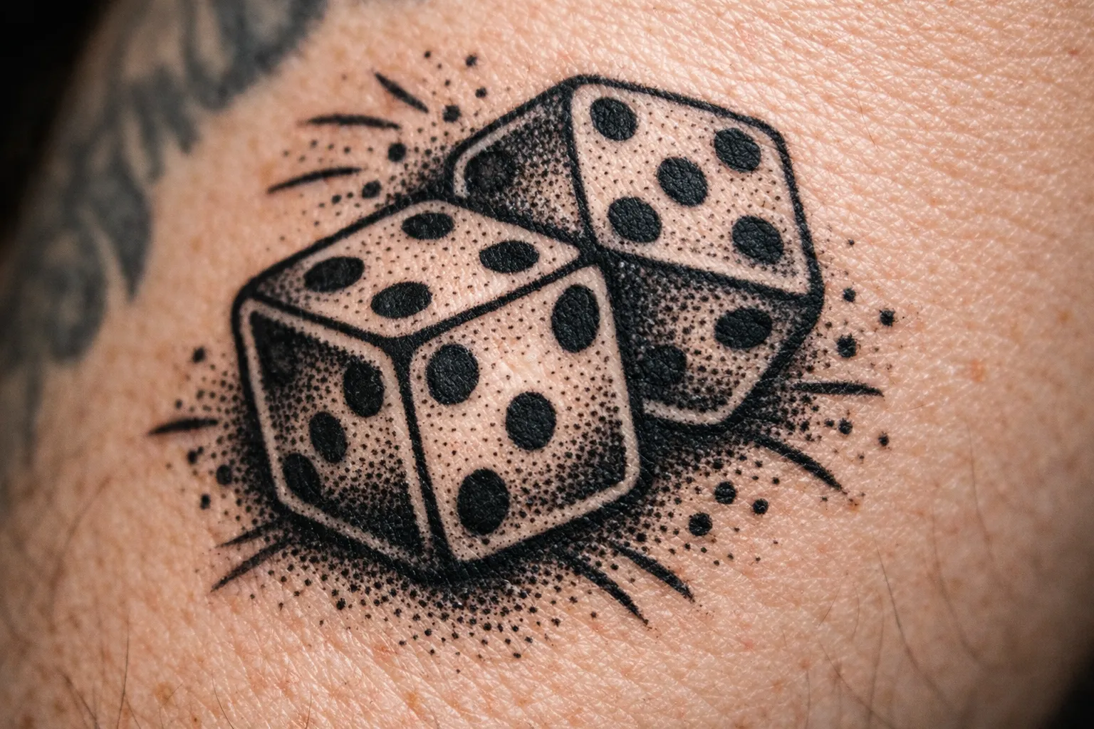 A close-up of a tattoo showing two dice on human skin.