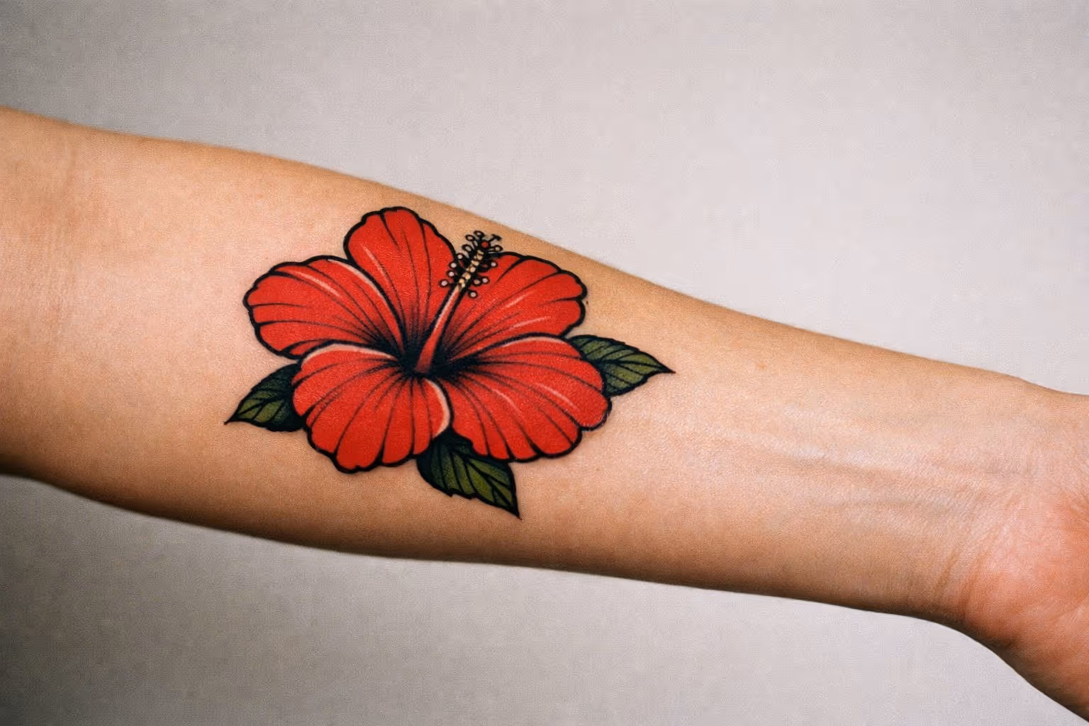 Hero shot: hibiscus tattoo on forearm, editorial close-up