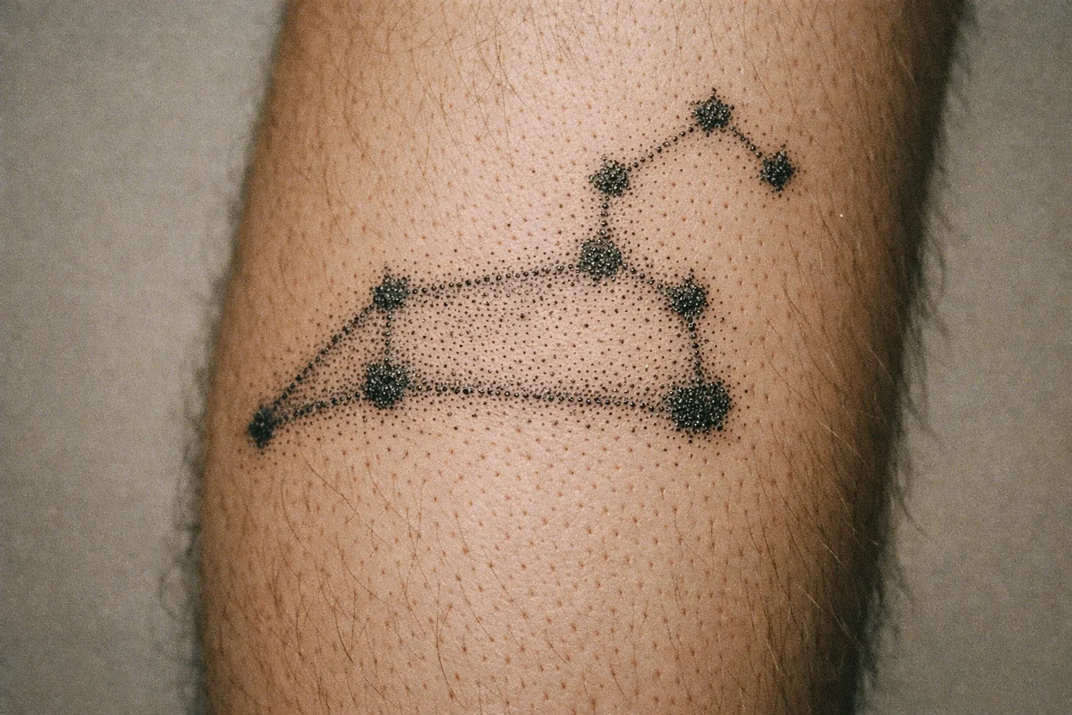 A Leo constellation tattoo is inked on a person's forearm.