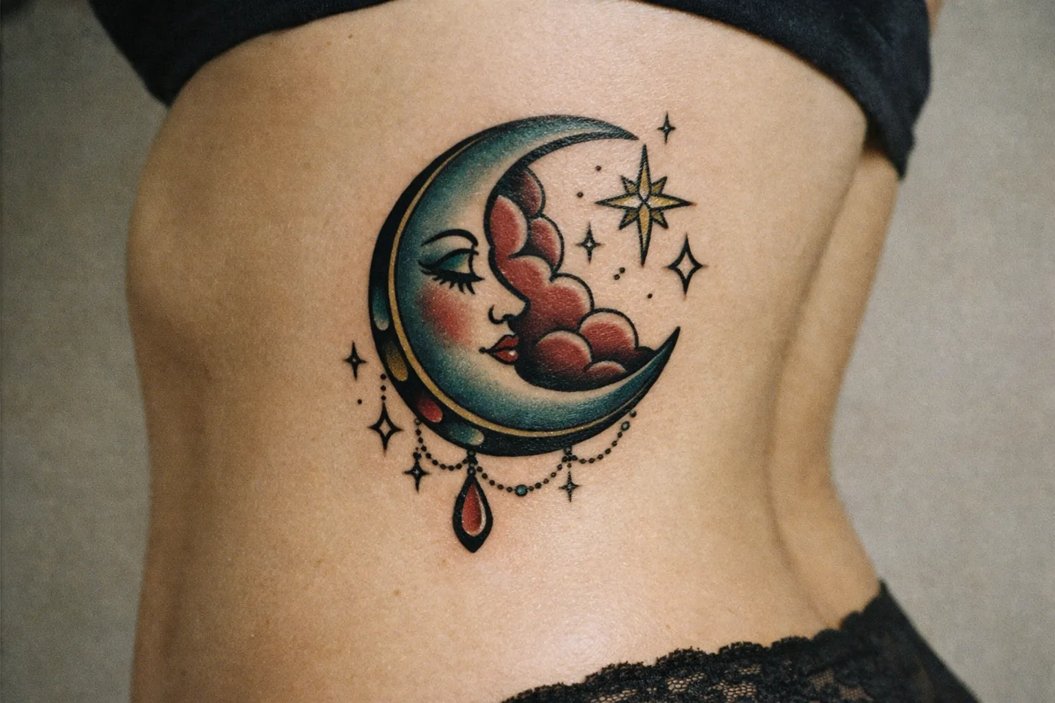 A person's side torso with a colorful crescent moon and star tattoo.