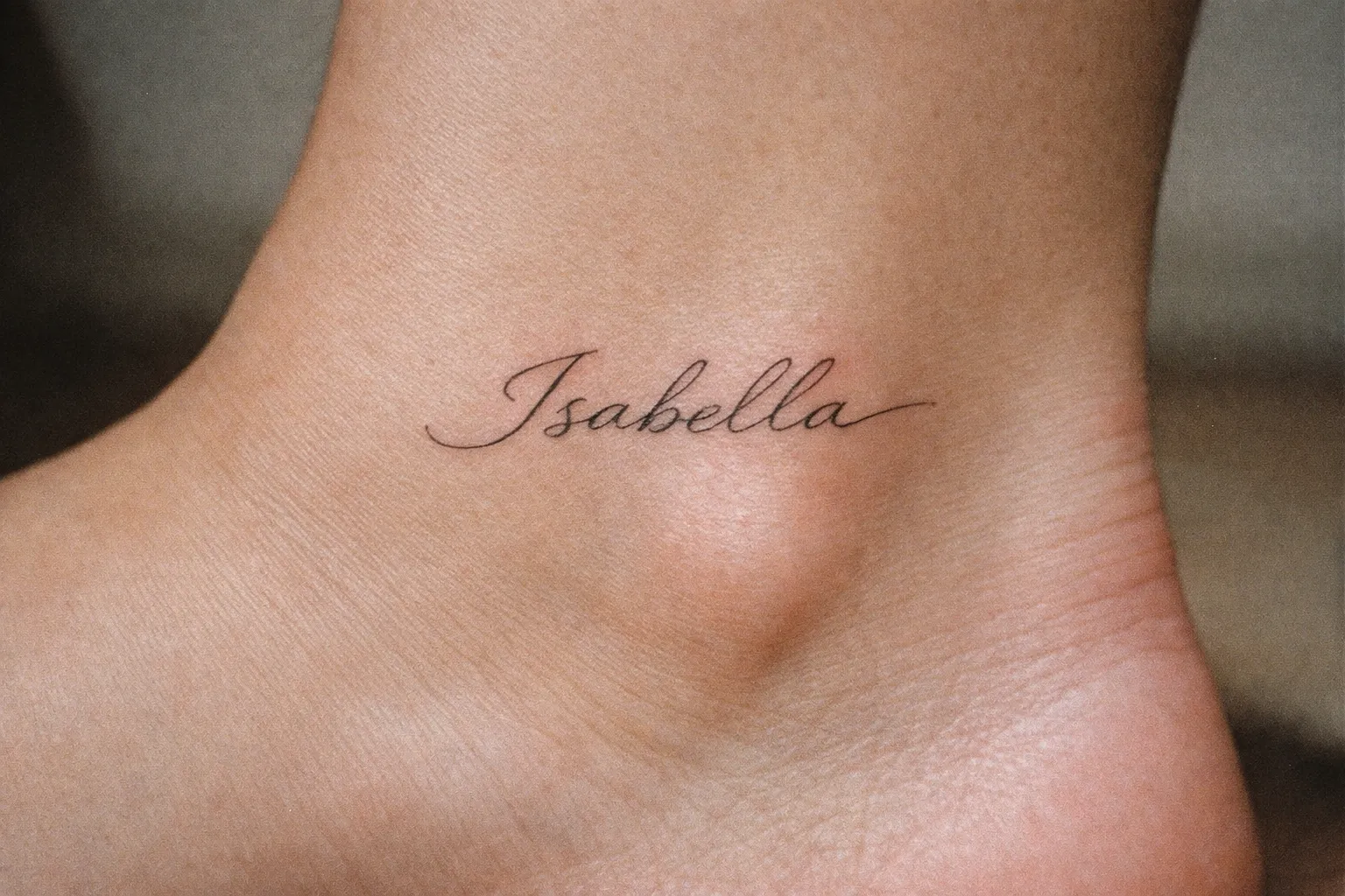 A foot with the name 'Isabella' tattooed in cursive on the ankle.