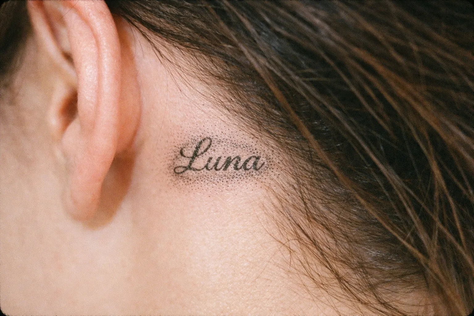 The word 'Luna' tattooed behind a person's ear.
