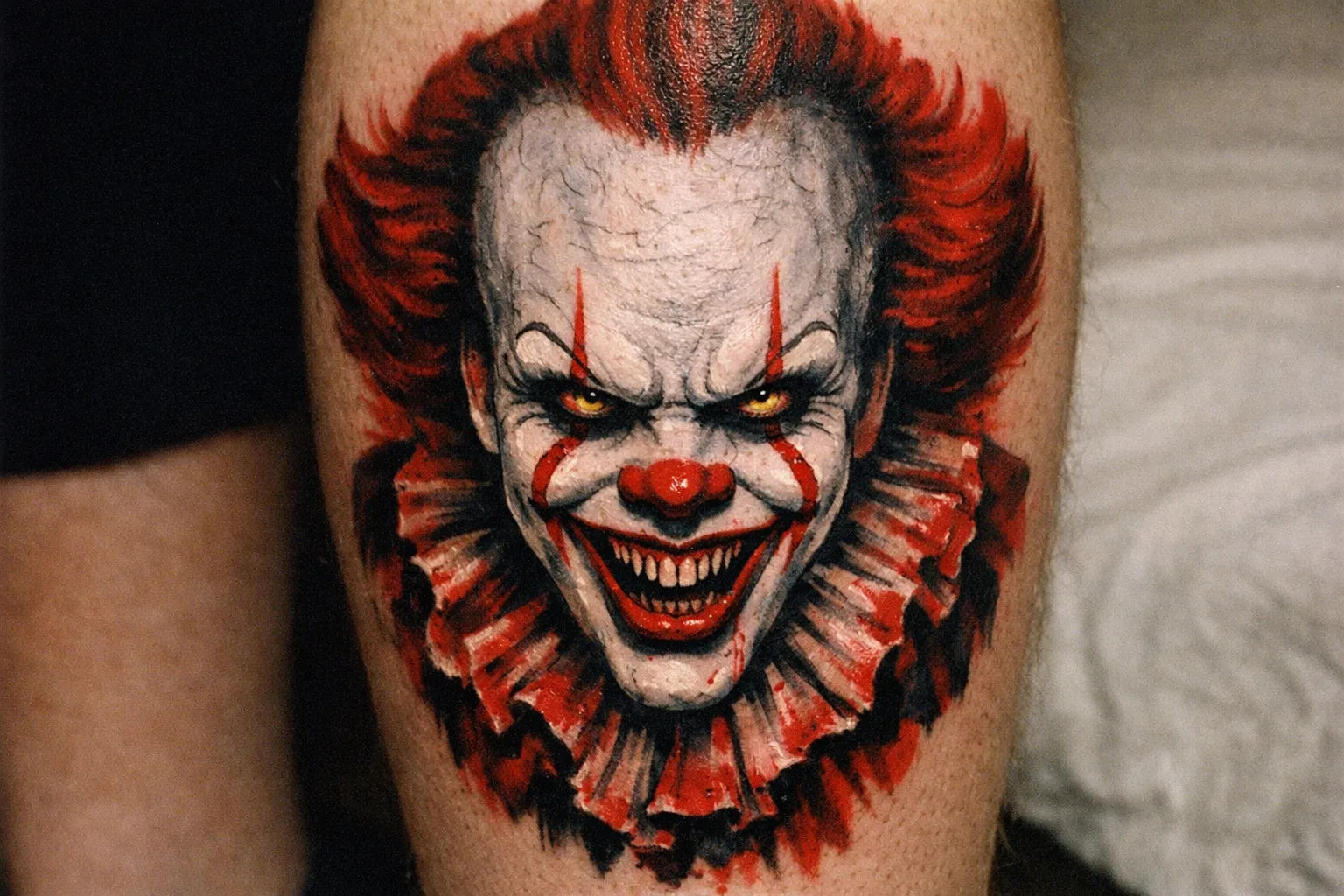 Full-color Pennywise portrait on calf showing saturated reds and blacks