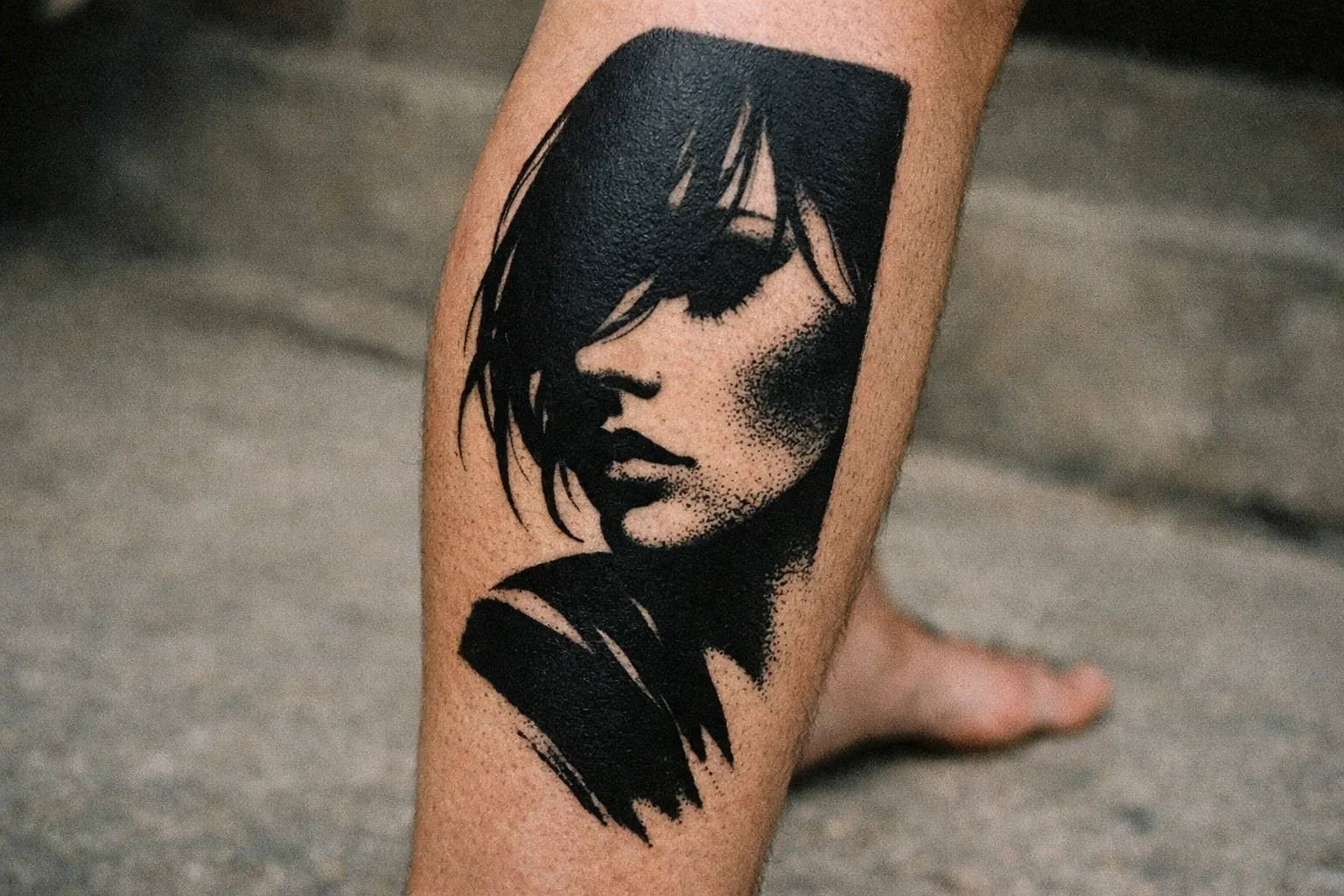 A tattoo of a woman's face is shown on the back of a person's lower leg outdoors.