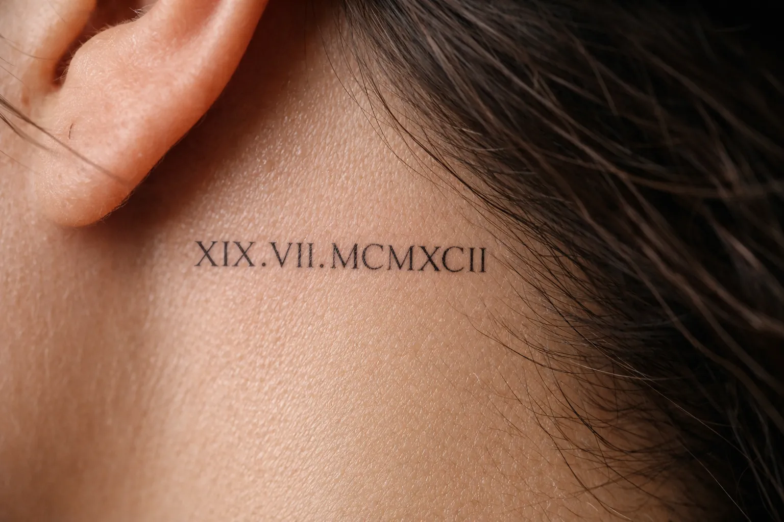 Roman numeral tattoo behind a person's ear.