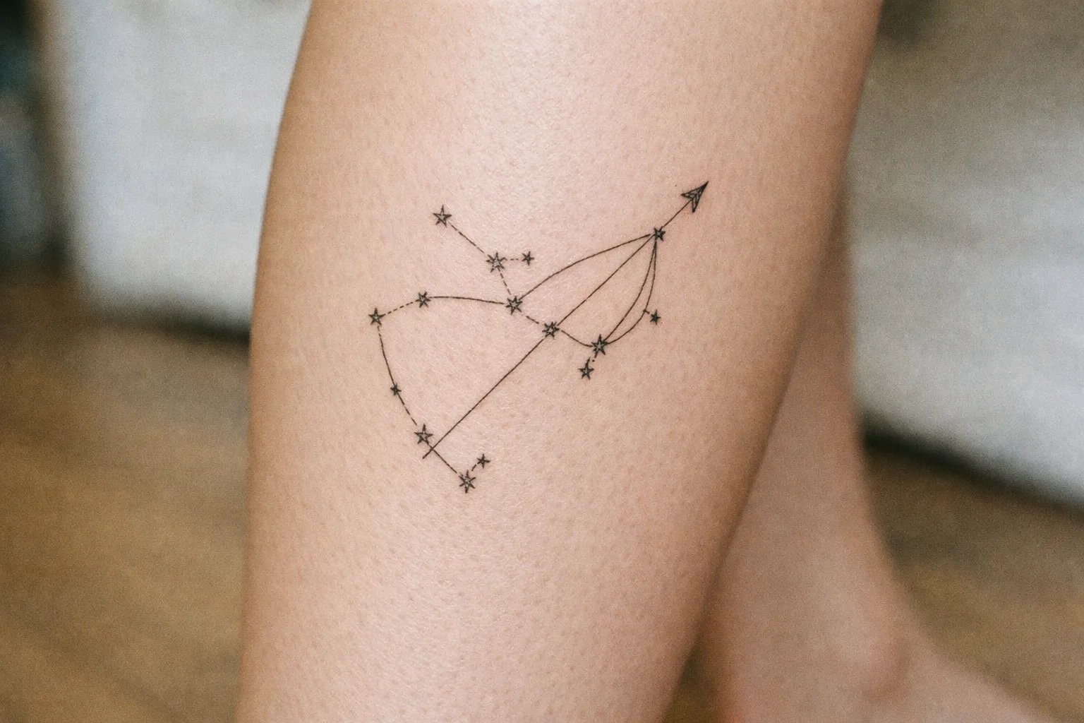 Calf tattoo featuring a delicate Sagittarius constellation along the calf