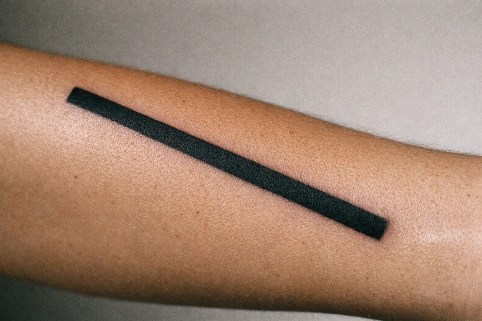Close-up of a forearm tattoo showing a blowout halo along the linework