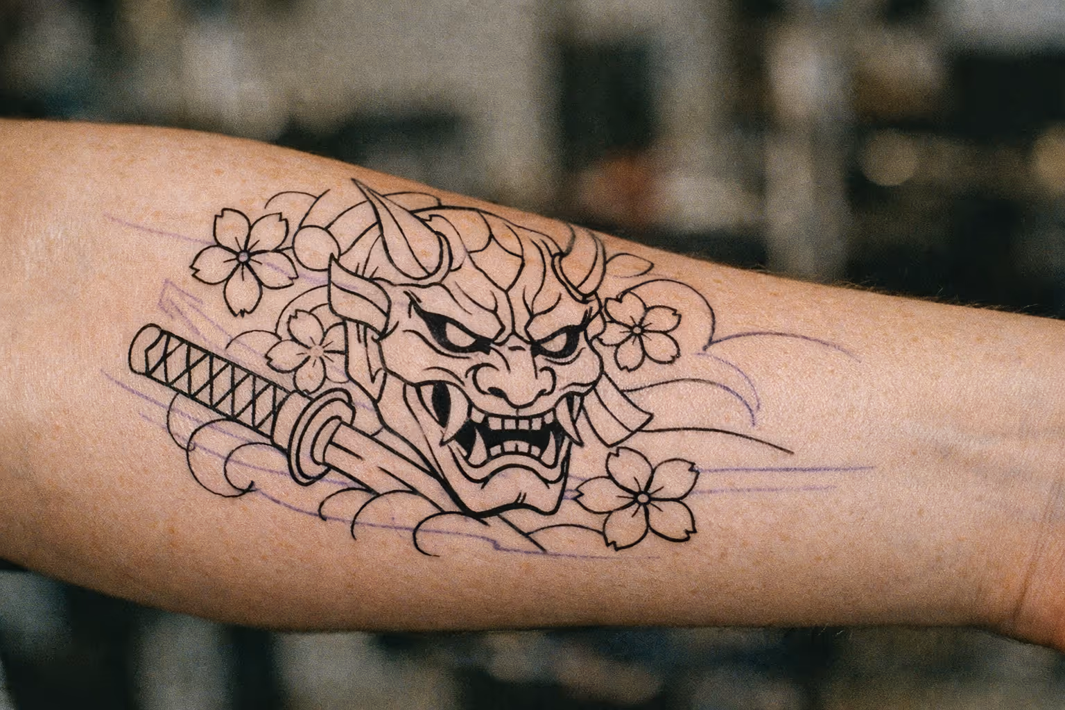 Editorial close-up of a forearm with a crisp stencil on the skin, illustrating stencil planning for a tattoo