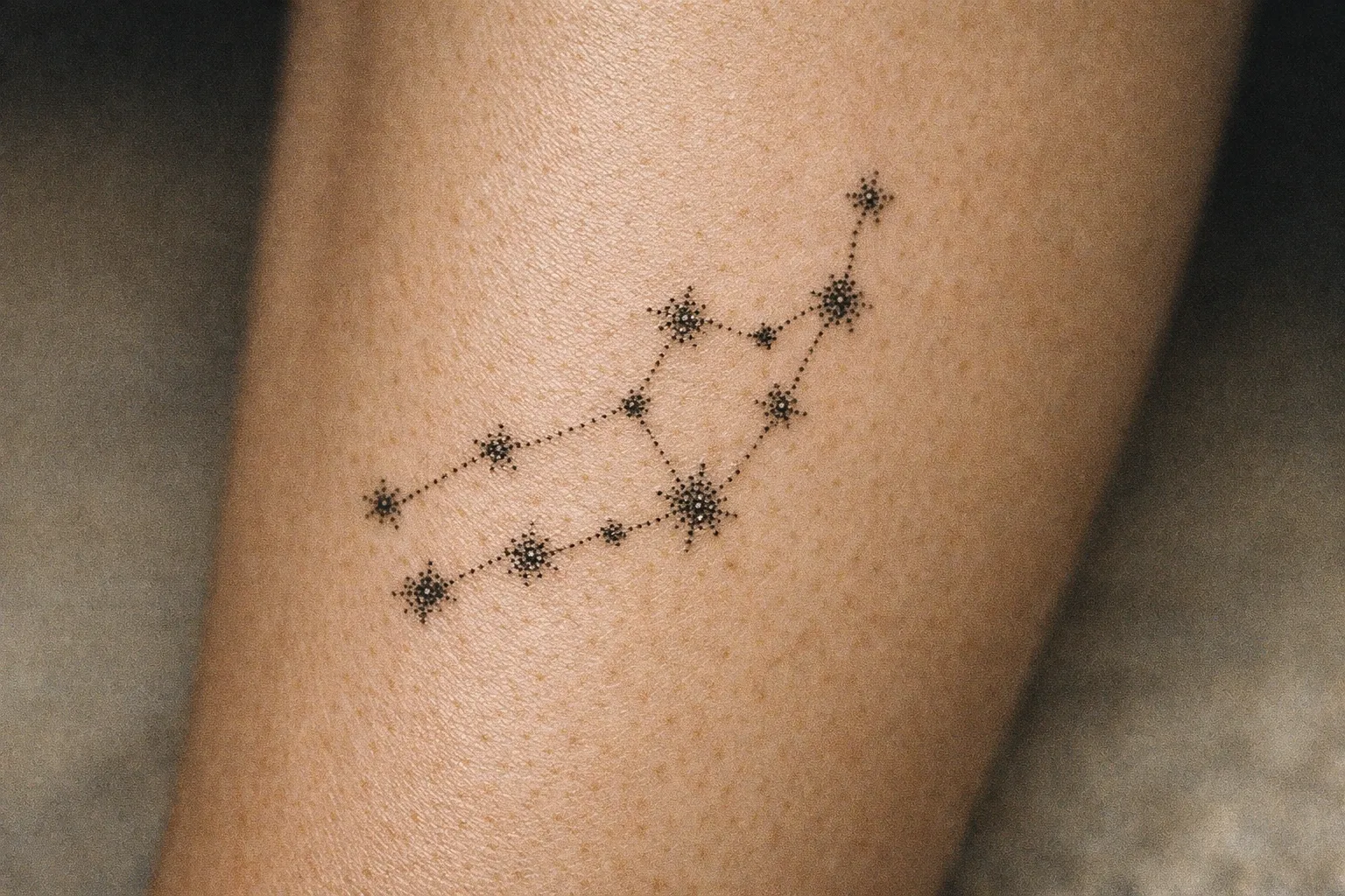 A Virgo constellation tattoo is inked on a person's forearm.