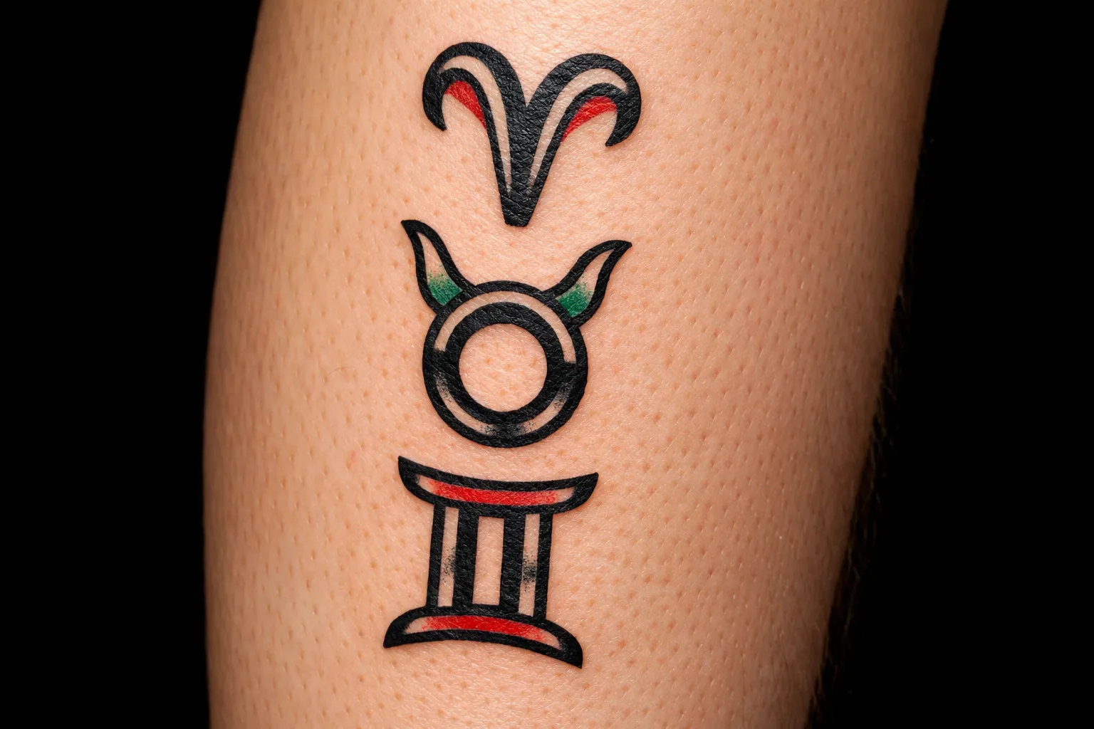 Three zodiac symbol tattoos on a person's leg.